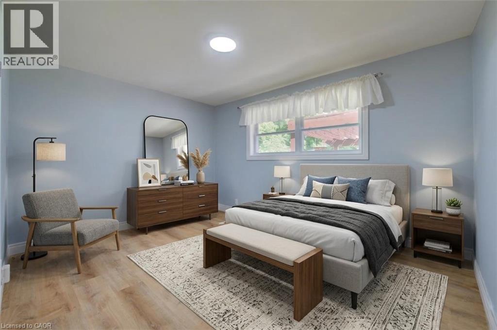 Recessed ceiling light, wood-finish flooring, light blue wall paint, white window trim, and a window with natural light - 251 Union Street E, Waterloo, ON - Indoor Photo Showing Bedroom