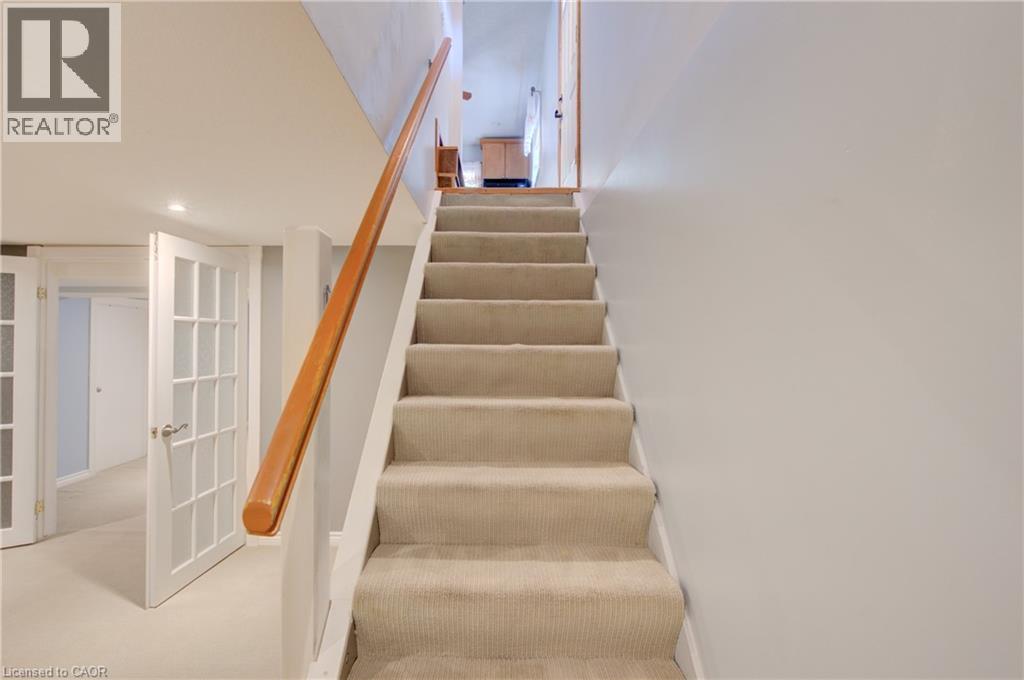 Carpeted staircase with a wood handrail, recessed lighting, and French doors - 251 Union Street E, Waterloo, ON - Indoor Photo Showing Other Room