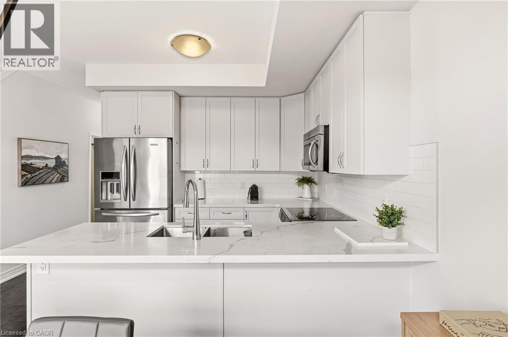 Kitchen featuring white shaker cabinetry, stainless steel appliances, white subway tile backsplash, and light-toned countertops - 4171 Palermo Common, Burlington, ON - Indoor Photo Showing Kitchen With Upgraded Kitchen