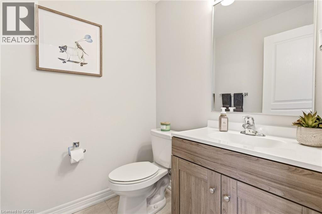 Spa-inspired bathroom featuring a wood-finish vanity with dual-sink configuration, white quartz countertop, and chrome fixtures - 4171 Palermo Common, Burlington, ON - Indoor Photo Showing Bathroom