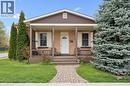 Brick facade with brown siding, covered front porch with wood columns and railing, front yard with mature landscaping, and a paver stone walkway - 27 Roseview Avenue, Cambridge, ON  - Outdoor With Deck Patio Veranda 