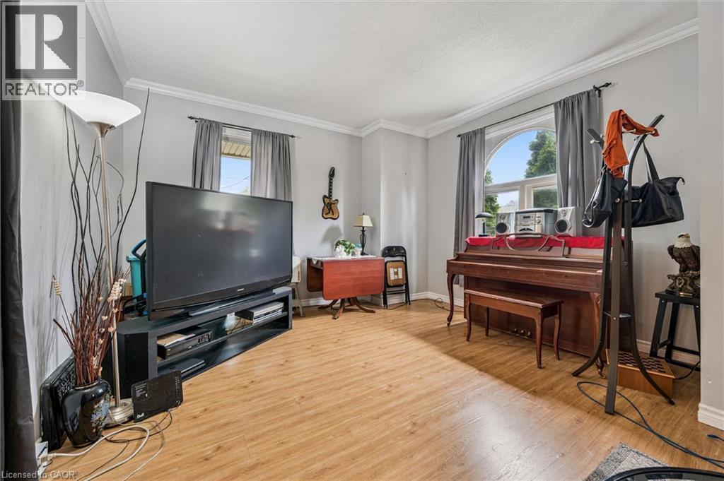 Wood-finish flooring throughout, crown molding, and an arched window - 27 Roseview Avenue, Cambridge, ON - Indoor Photo Showing Living Room