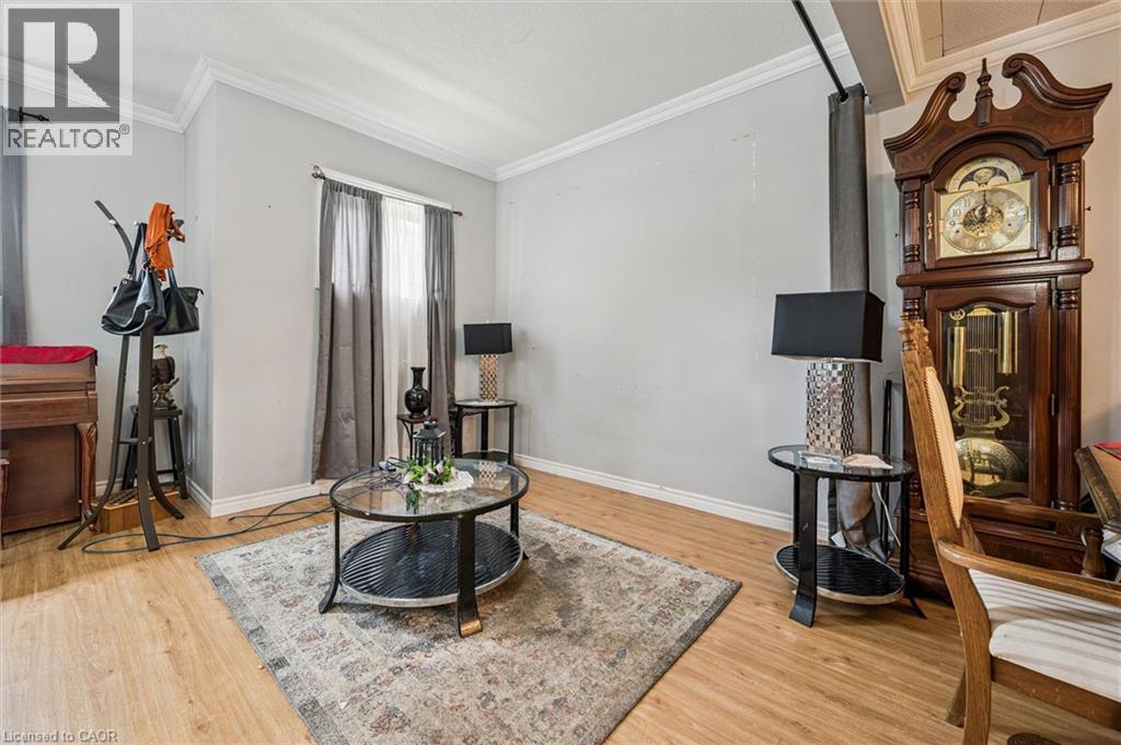 Light-toned wood-finish flooring, white crown molding, and a window with neutral-toned drapes - 27 Roseview Avenue, Cambridge, ON - Indoor