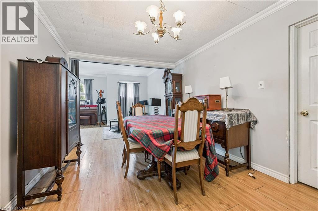 Wood-finish flooring throughout, crown molding, and a traditional chandelier - 27 Roseview Avenue, Cambridge, ON - Indoor Photo Showing Dining Room