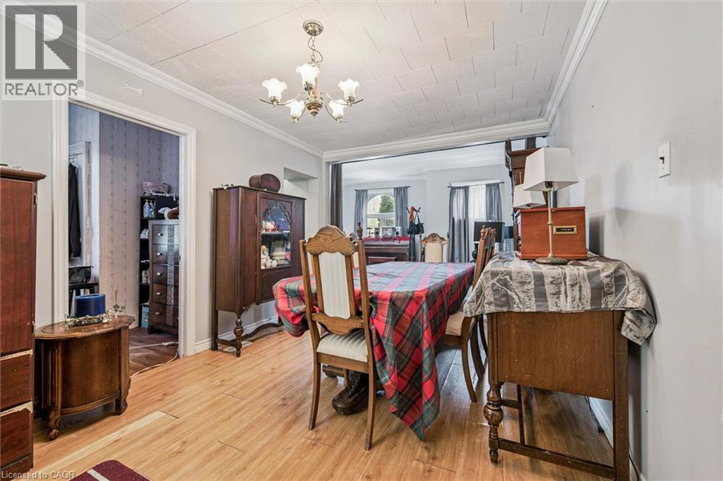 Wood-finish flooring with crown molding and a ceiling-mounted light fixture - 27 Roseview Avenue, Cambridge, ON - Indoor Photo Showing Dining Room