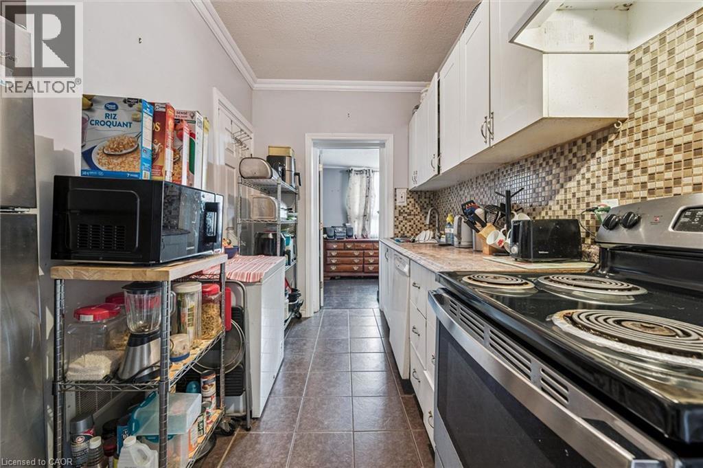 Kitchen featuring white cabinetry, a tiled backsplash, and resilient tile flooring - 27 Roseview Avenue, Cambridge, ON - Indoor Photo Showing Kitchen