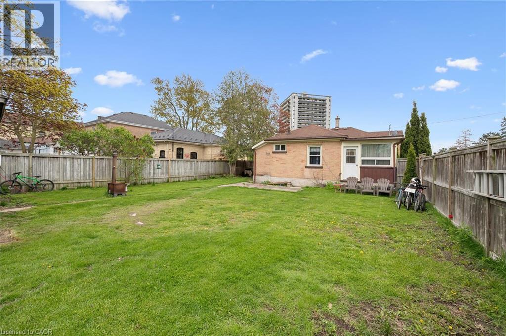 Expansive backyard featuring a mature, manicured lawn bordered by wooden privacy fencing - 27 Roseview Avenue, Cambridge, ON - Outdoor With Backyard