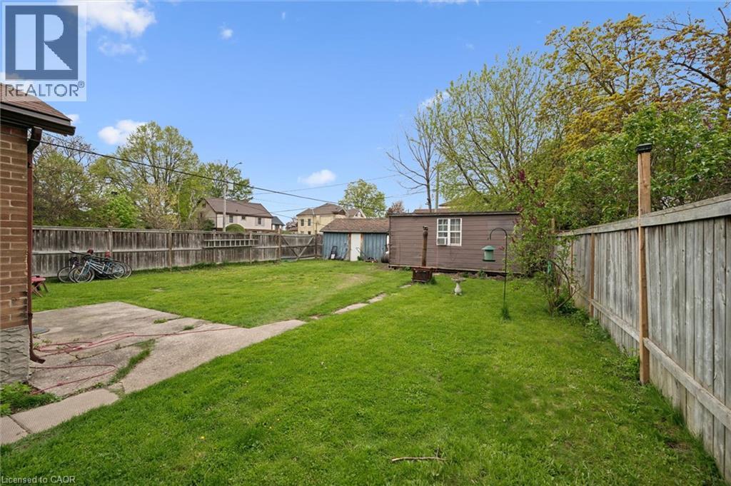 Expansive green lawn, concrete patio, wood fence, and a detached shed - 27 Roseview Avenue, Cambridge, ON - Outdoor