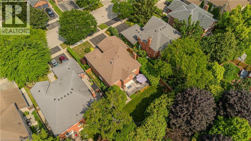 Residential property with a brick exterior, shingle roof, and a private backyard featuring a patio and surrounding greenery - 1238 Sable Drive, Burlington, ON - Outdoor With View