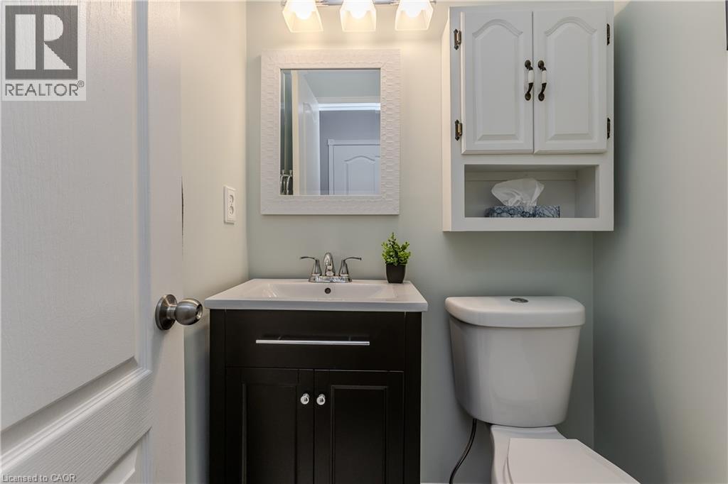 Dark wood vanity with a white integrated sink and chrome faucet - 1238 Sable Drive, Burlington, ON - Indoor Photo Showing Bathroom