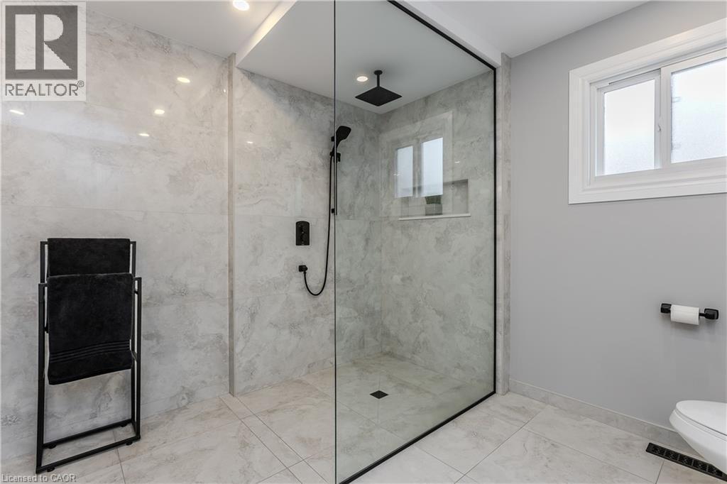 Glass-enclosed shower with black-framed detailing, recessed lighting, and a built-in shower niche - 1238 Sable Drive, Burlington, ON - Indoor Photo Showing Bathroom