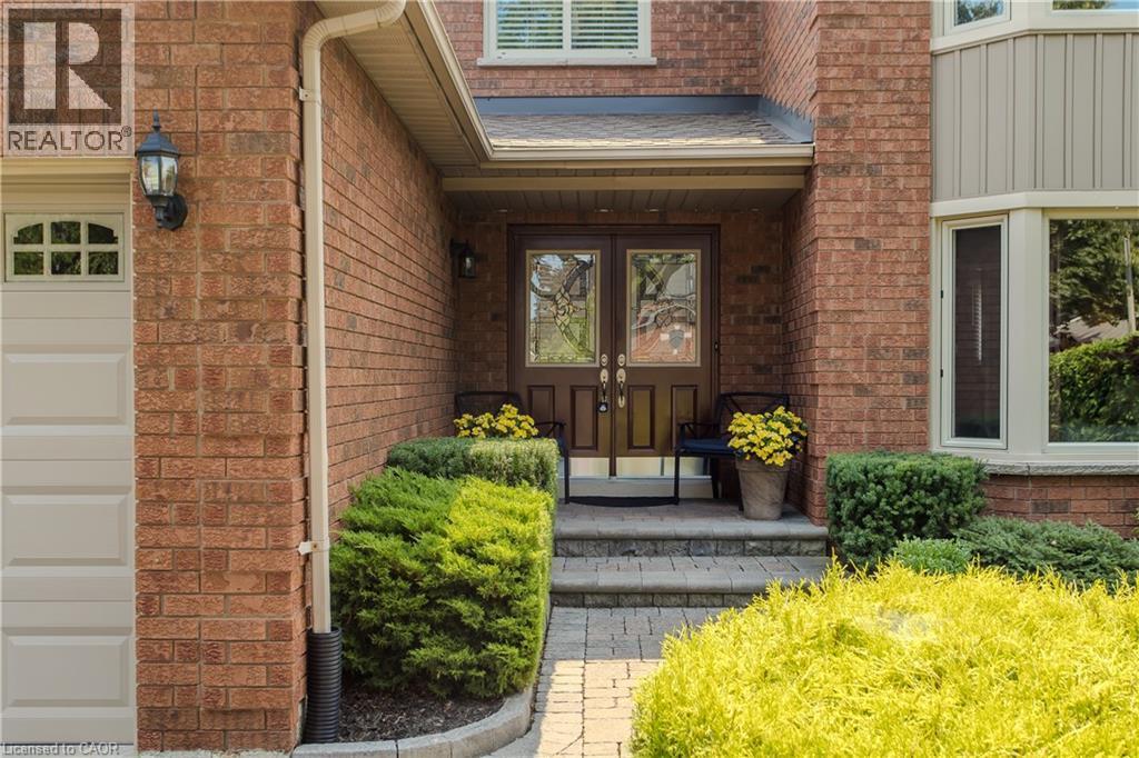 Brick exterior with a stone paver walkway, double entry doors with decorative glass panels, and a bay window - 1238 Sable Drive, Burlington, ON - Outdoor With Exterior