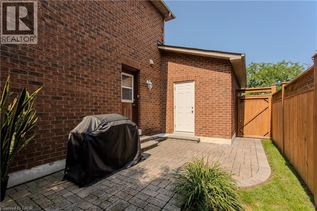 Brick exterior, paver patio, wood fencing, exterior entry door, and a separate exterior door - 1238 Sable Drive, Burlington, ON - Outdoor With Exterior