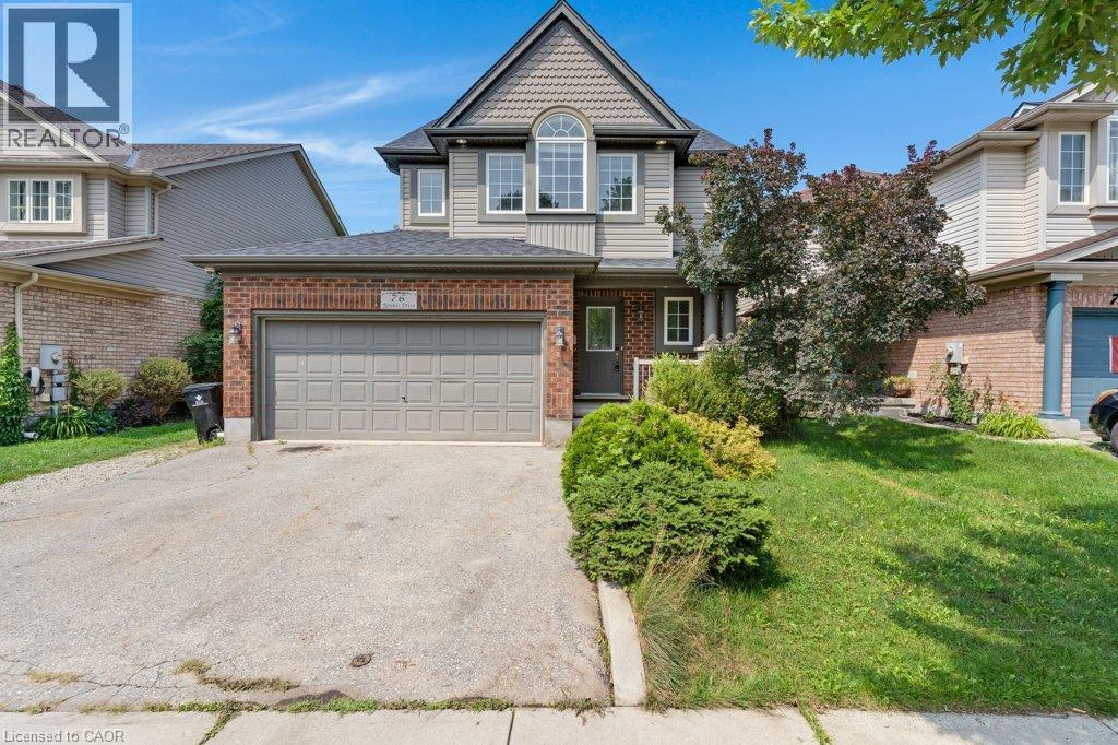 Two-story residence featuring a brick and siding facade, an arched window, an attached two-car garage, and a concrete driveway - 76 Renner Drive, Cambridge, ON - Outdoor With Facade