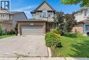 Two-story residence featuring a brick and siding facade, an arched window, an attached two-car garage, and a concrete driveway - 76 Renner Drive, Cambridge, ON  - Outdoor With Facade 