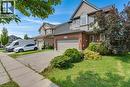 Brick and siding exterior with an integrated garage, arched window, and mature landscaping - 76 Renner Drive, Cambridge, ON  - Outdoor With Facade 