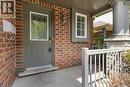 Brick facade with a covered entry, featuring a decorative glass panel door, a porch light fixture, and a window with white blinds - 76 Renner Drive, Cambridge, ON  - Outdoor With Deck Patio Veranda With Exterior 