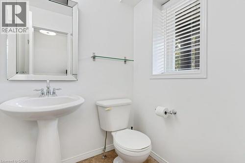 Pedestal sink with chrome fixtures, reflective framed mirror, glass shelf, and a window with blinds - 76 Renner Drive, Cambridge, ON - Indoor Photo Showing Bathroom
