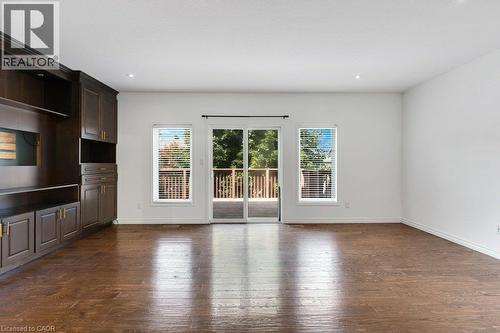 Hardwood flooring, dark wood built-in cabinetry, recessed lighting, and a sliding glass door with an exterior deck - 76 Renner Drive, Cambridge, ON - Indoor