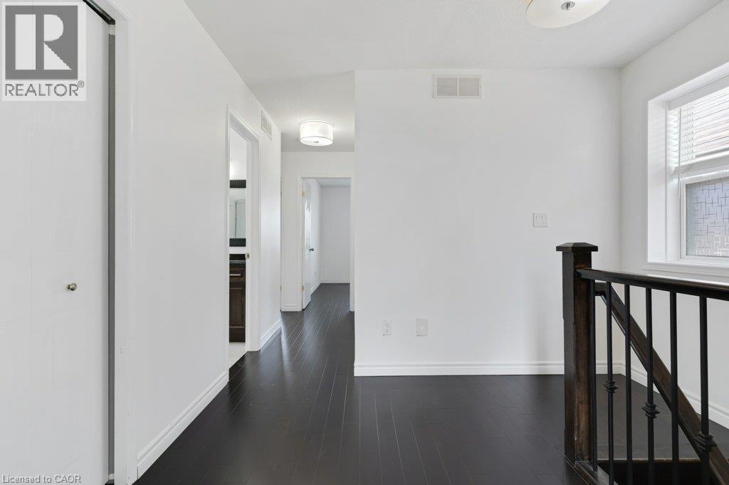 Dark wood-finish flooring with white trim - 76 Renner Drive, Cambridge, ON - Indoor Photo Showing Other Room