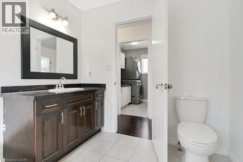 Bathroom featuring a dark wood-finish vanity with an undermount sink, dark countertop, and a framed mirror - 76 Renner Drive, Cambridge, ON - Indoor Photo Showing Bathroom
