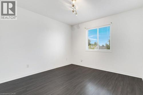Wood-finish flooring, white baseboards, track lighting, and a window with blinds - 76 Renner Drive, Cambridge, ON - Indoor Photo Showing Other Room