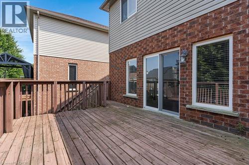 Expansive wood deck with full railing, brick exterior, and sliding glass door with dual side windows - 76 Renner Drive, Cambridge, ON - Outdoor With Deck Patio Veranda With Exterior