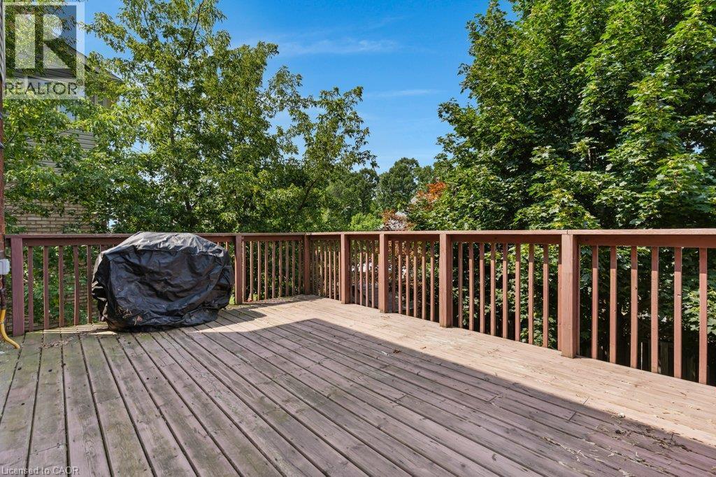 Expansive wood-finish deck with a wood railing, surrounded by mature trees - 76 Renner Drive, Cambridge, ON - Outdoor With Deck Patio Veranda