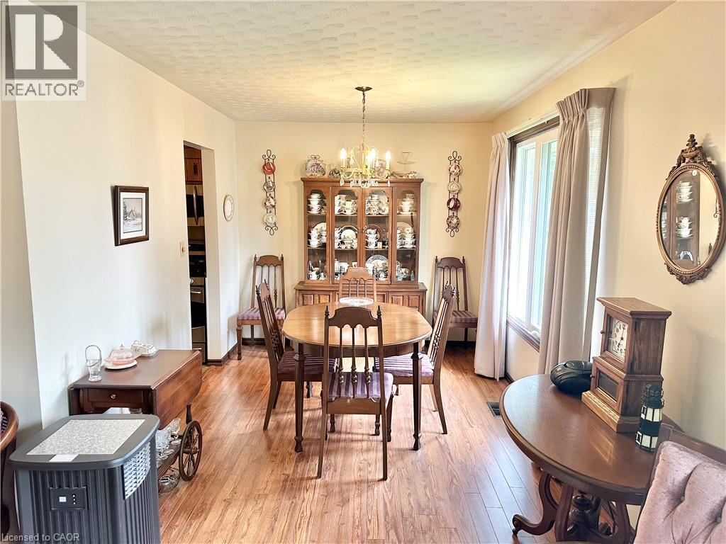 Dining Room - with laminate flooring with a ceiling-mounted light fixture, recessed window, and built-in display cabinetry - 44 Douglas Avenue, Simcoe, ON - Indoor Photo Showing Dining Room