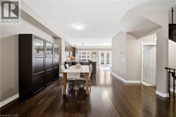 Dark wood-finish flooring throughout, recessed ceiling lighting, and built-in cabinetry with glass paneling - 