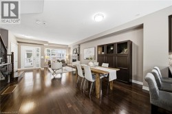 Hardwood flooring, French doors with louvered blinds, large windows with louvered blinds, stone-clad fireplace, and built-in cabinetry - 
