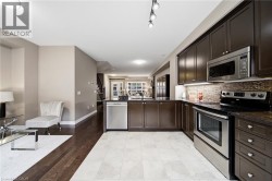 Rich wood-finish cabinetry, stainless steel appliances, mosaic tile backsplash, and track lighting - 
