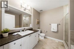 Vanity with white cabinetry, dark countertop, and integrated rectangular sink - 