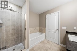 Full-size shower with glass enclosure, separate soaking tub, and vanity with integrated sink - 