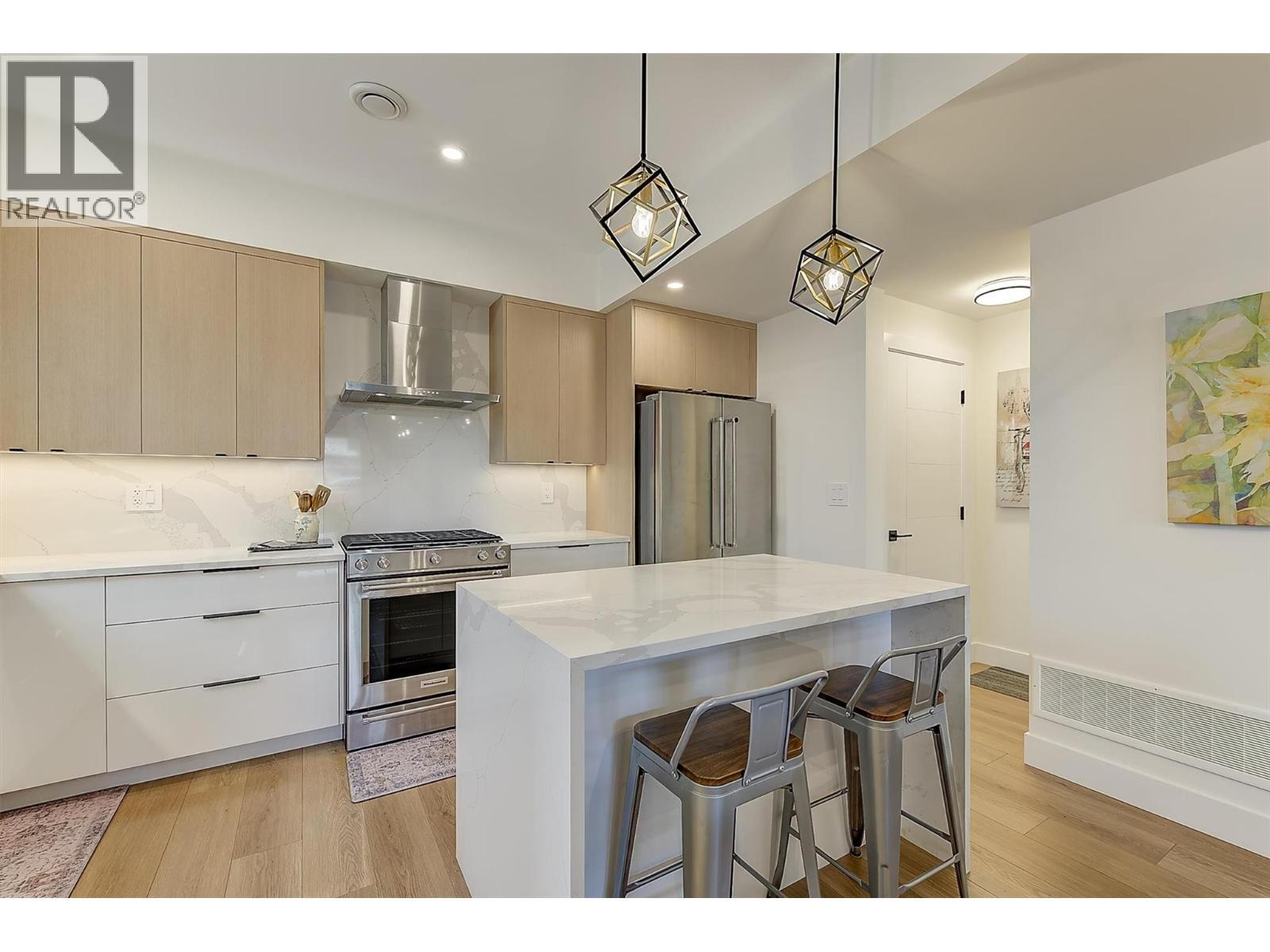 Quartz counters • waterfall island • KitchenAid appliances - 747 Patterson Avenue Unit# 2, Kelowna, BC - Indoor Photo Showing Kitchen With Upgraded Kitchen