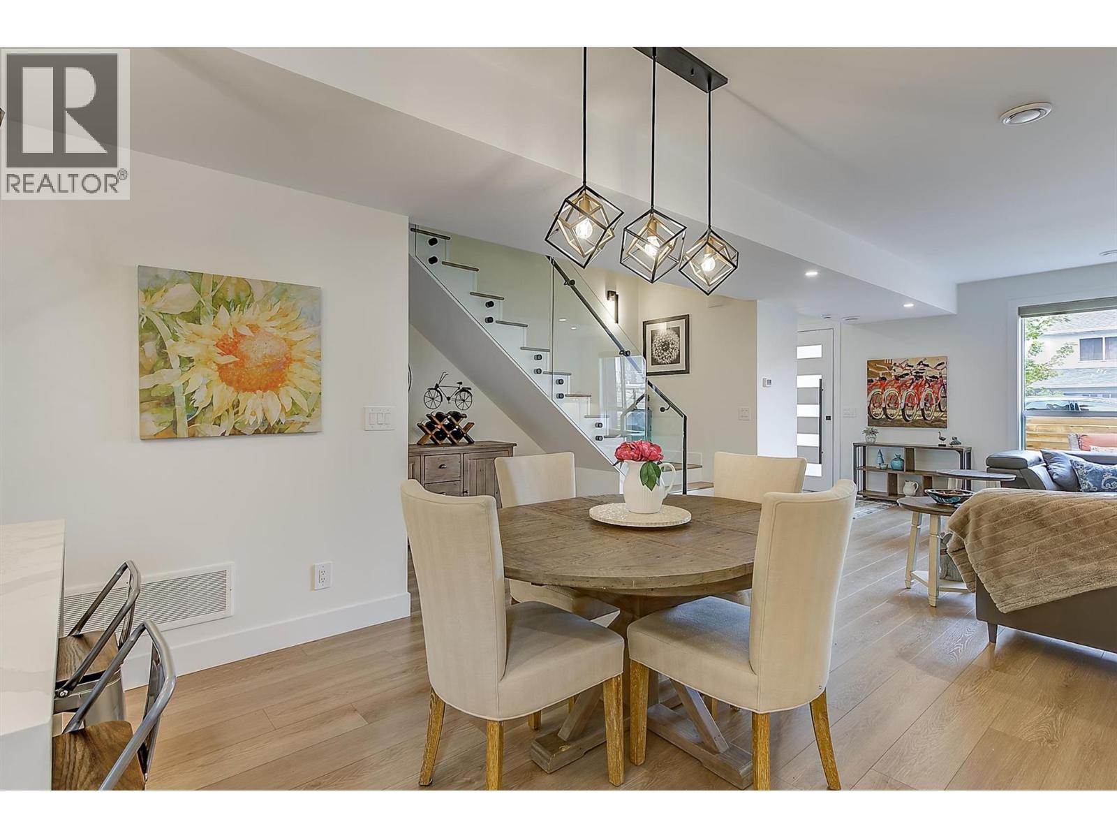 Bright, contemporary open-concept living with striking glass railings and seamless flow between the living and dining areas. - 747 Patterson Avenue Unit# 2, Kelowna, BC - Indoor Photo Showing Dining Room