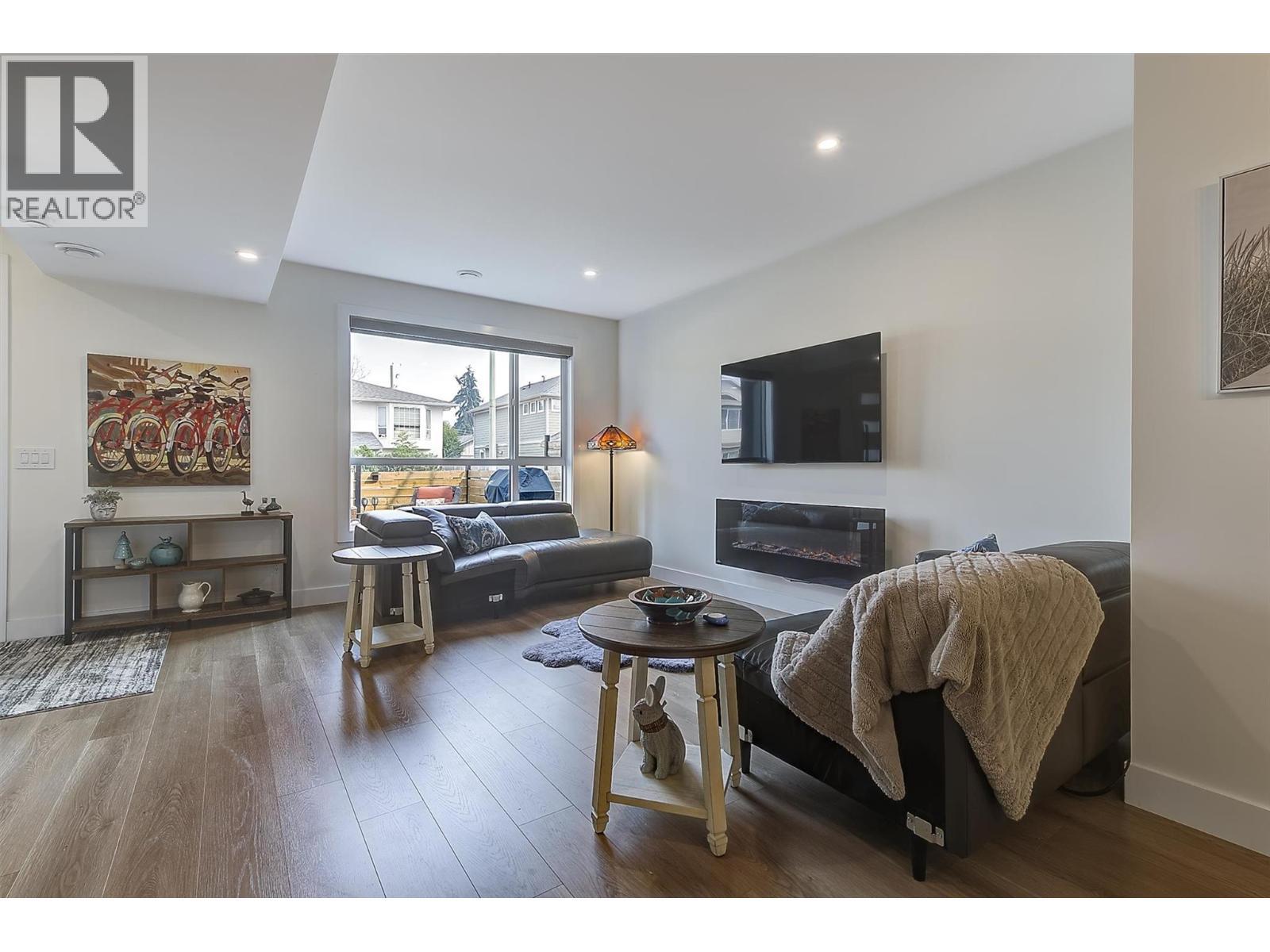 Wall-mounted TV setup keeps cords concealed for a clean, streamlined look - 747 Patterson Avenue Unit# 2, Kelowna, BC - Indoor Photo Showing Living Room With Fireplace