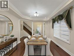 Hardwood-finish flooring, crown molding, decorative columns, coffered ceiling, and a prominent window - 