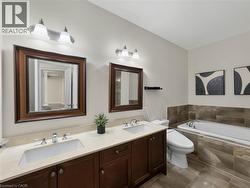 Dual vanity with wood-finish cabinetry, under-mount sinks, and chrome faucets - 