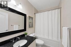 Vanity with dark countertop, undermount sink, and chrome faucet - 