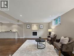 Recessed lighting, wood-finish flooring, built-in wet bar with cabinetry and countertop, built-in fireplace, and a window - 