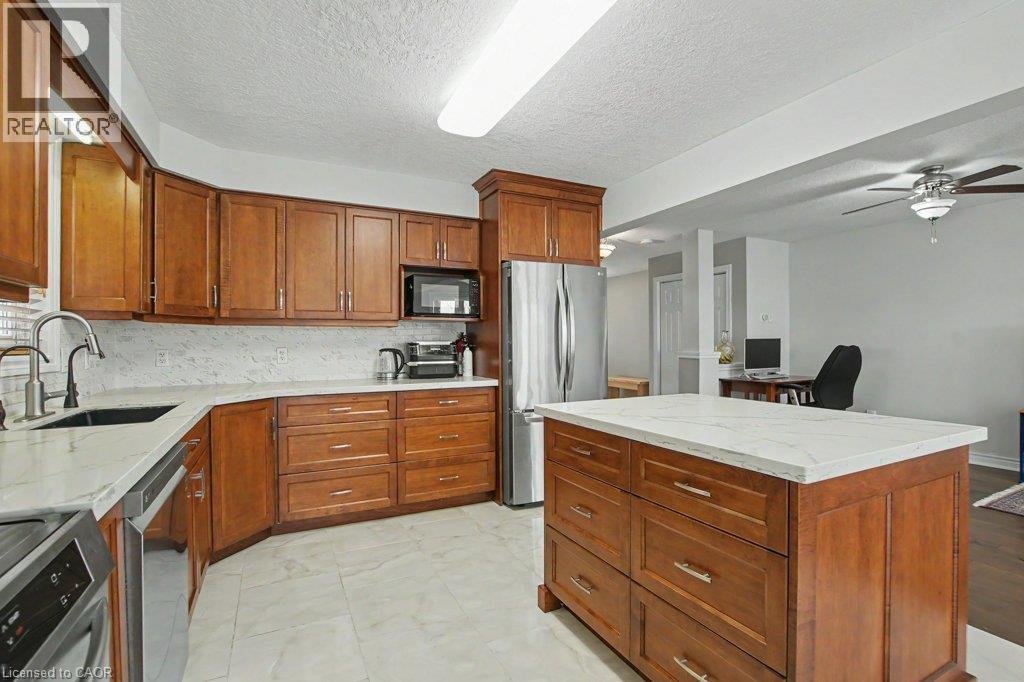 Kitchen featuring Maple wood cabinetry and a centre island with quartz counter and integrated drawers - 568 Robert Ferrie Drive, Kitchener, ON - Indoor Photo Showing Kitchen
