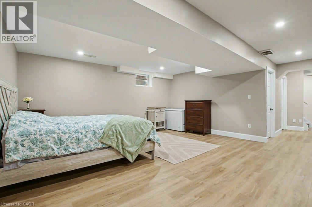 Bright, spacious rec-room with light-toned wood-finish flooring, recessed lighting, and neutral wall paint - 568 Robert Ferrie Drive, Kitchener, ON - Indoor Photo Showing Basement