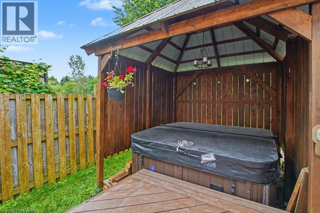 Gazebo with hot-tub, a metal roof, wood-finish walls, and a built-in chandelier - 568 Robert Ferrie Drive, Kitchener, ON - Outdoor With Exterior