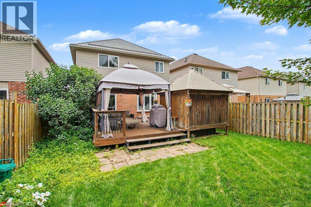 Expansive backyard featuring a wood deck, wood privacy fencing, and mature greenery - 568 Robert Ferrie Drive, Kitchener, ON - Outdoor With Deck Patio Veranda With Exterior