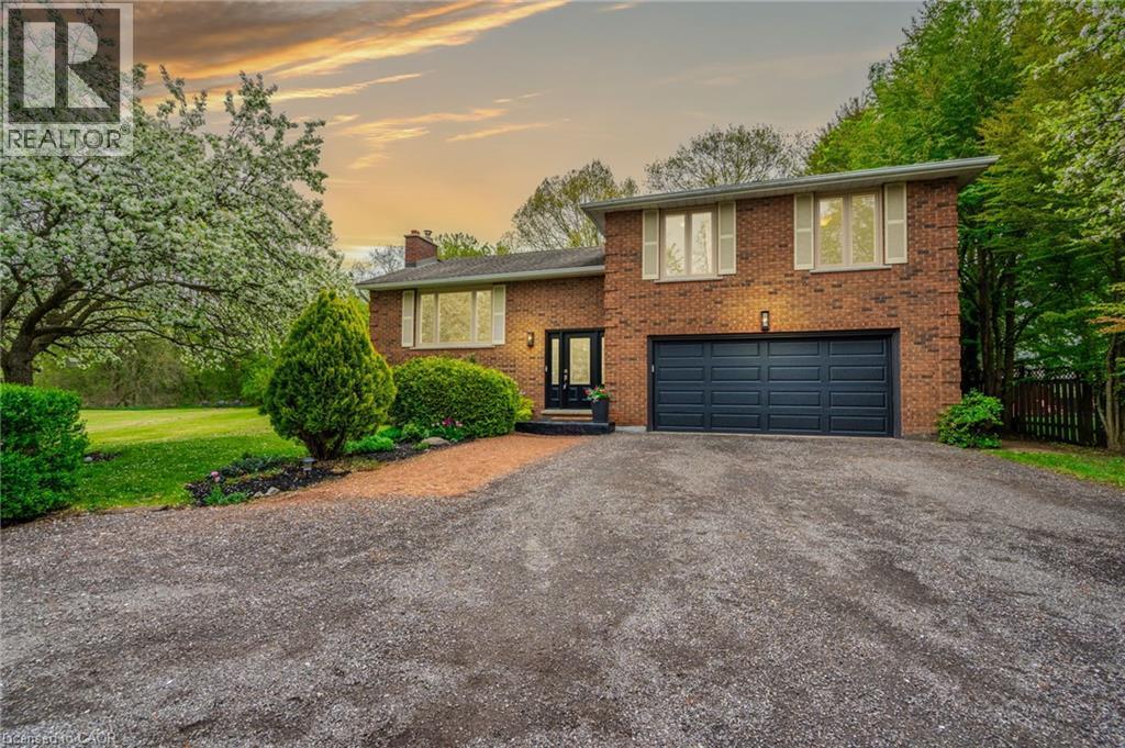 Brick exterior with an attached two-car garage, large windows, and mature landscaping - 152 Concession 7 Road E, Millgrove, ON - Outdoor