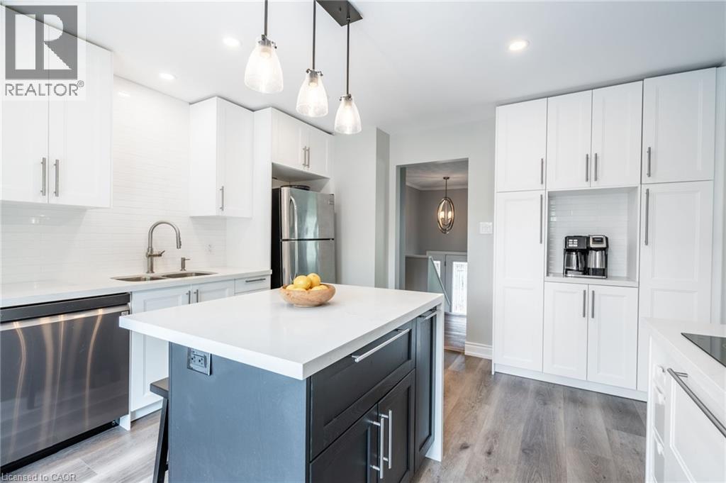 White shaker cabinetry, stainless steel appliances, white subway tile backsplash, white countertop surfaces, and a two-tone kitchen island - 152 Concession 7 Road E, Millgrove, ON - Indoor Photo Showing Kitchen With Double Sink With Upgraded Kitchen