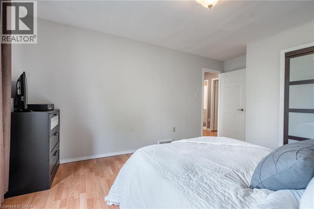 Wood-finish flooring, light grey wall paint, and a semi-flush ceiling light fixture - 152 Concession 7 Road E, Millgrove, ON - Indoor Photo Showing Bedroom