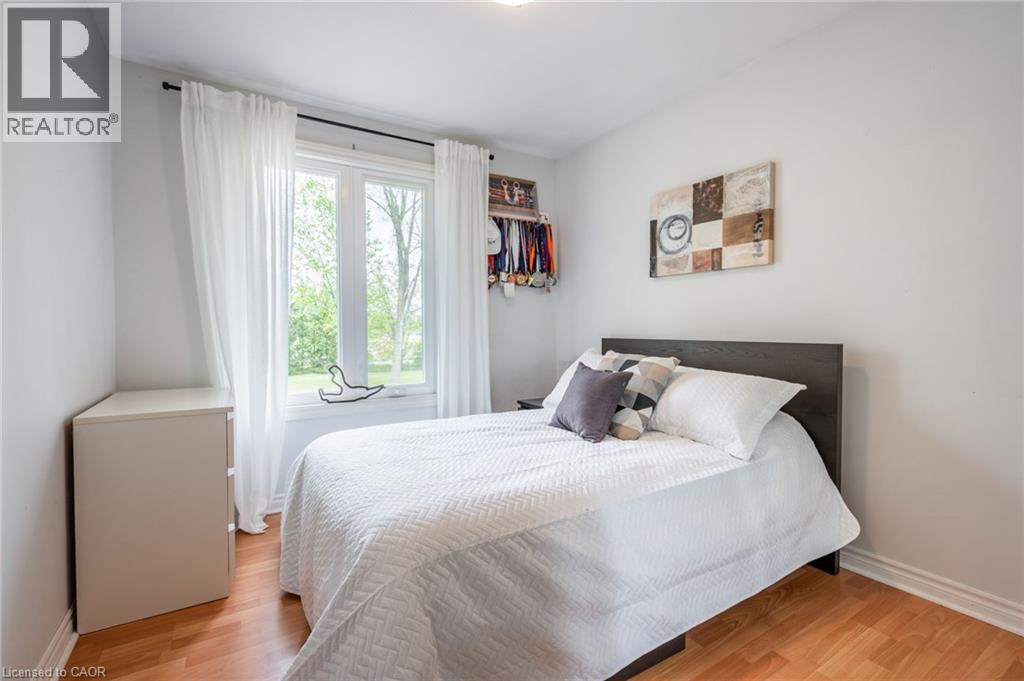 Wood-finish flooring with white baseboards and a large window with white window treatments - 152 Concession 7 Road E, Millgrove, ON - Indoor Photo Showing Bedroom
