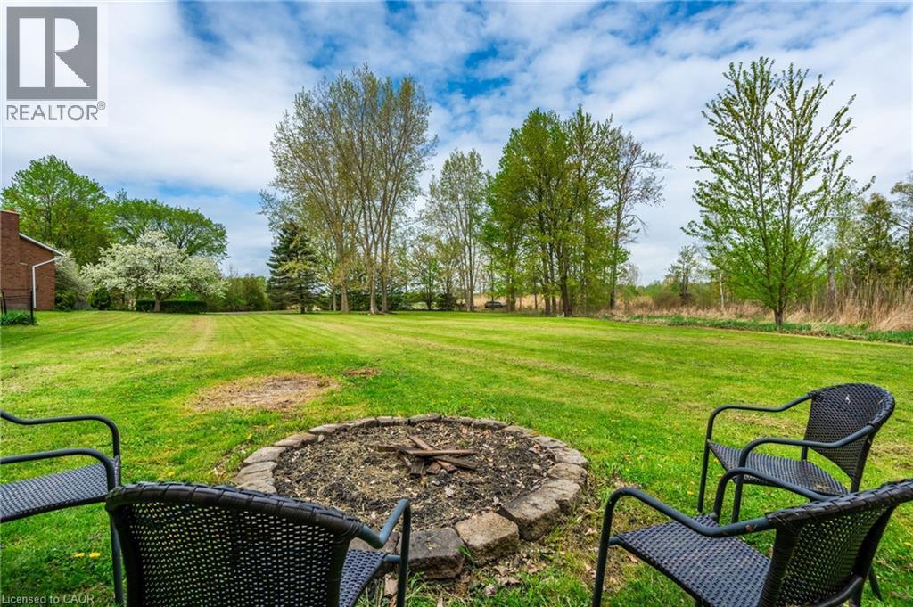 Expansive green lawn with a stone-edged fire pit - 152 Concession 7 Road E, Millgrove, ON - Outdoor